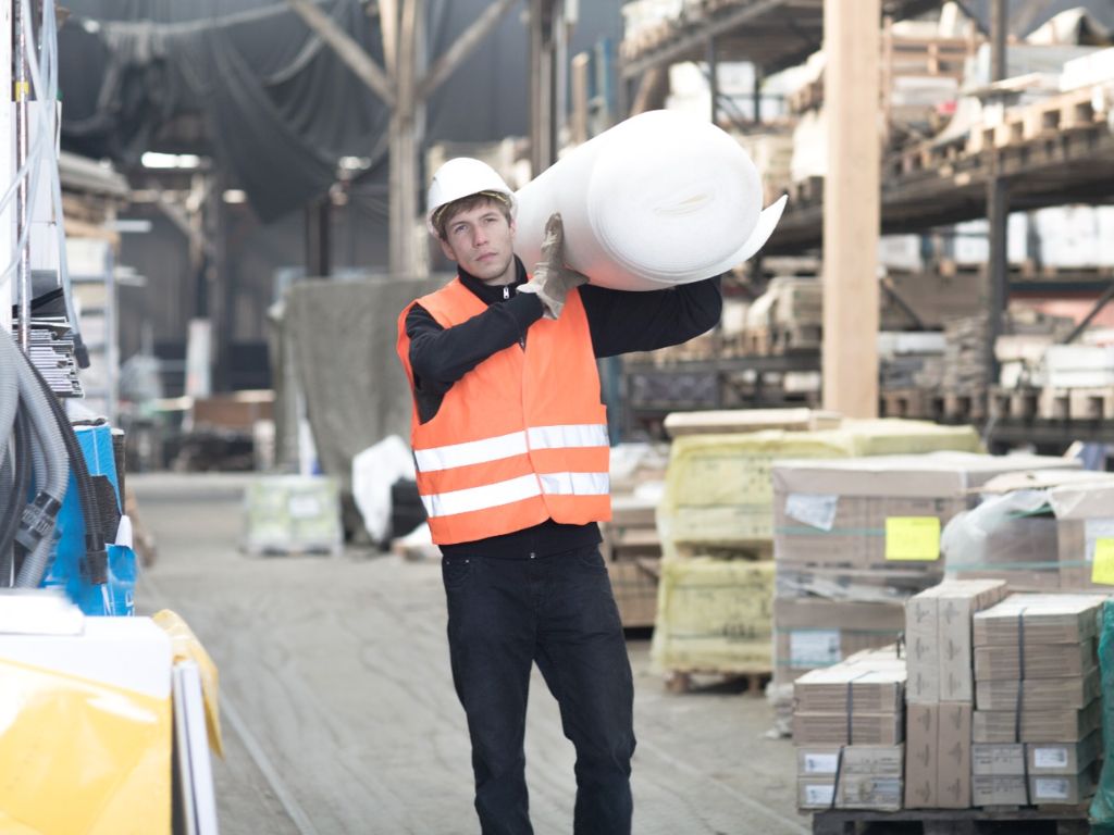 construction supply worker manually handling heavy product