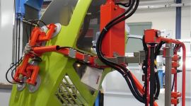 Industrial vacuum lifting manipulator handling an automotive body panel for safe, precise, and ergonomic material handling during vehicle manufacturing
