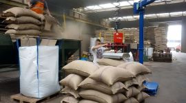 Vacuum sack lifting manipulator handling heavy bags in a warehouse for safe, ergonomic, and efficient material handling.