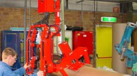 Dalmec pneumatic manipulator lifting a heavy industrial filter for safe handling in a mining maintenance facility