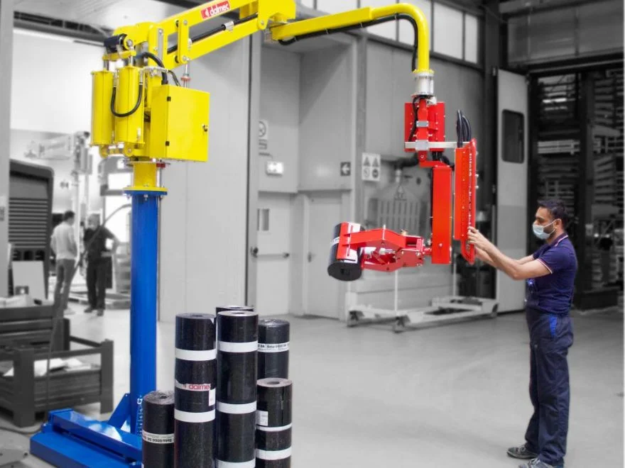 Dalmec lift assist manipulator handling rolled insulation material as a worker in PPE guides the load.