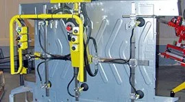 Dalmec manipulator with custom gripping frame handling a large automotive bodywork panel in a vehicle manufacturing facility