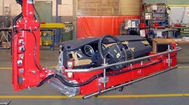 Dalmec manipulator with custom gripping frame handling a full automotive dashboard assembly in a vehicle manufacturing facility