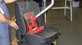 Dalmec manipulator with custom gripping tool handling a vehicle seat during automotive assembly, allowing precise placement by a single operato