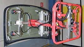 Dalmec manipulator with vacuum suction cup frame handling a large automotive windscreen glass panel on a vehicle assembly line