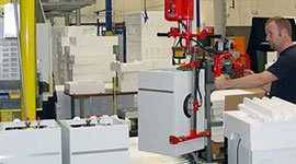 Dalmec manipulator with custom gripping tool handling large white goods electrical appliances in a manufacturing facility