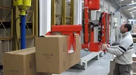 Dalmec manipulator with mechanical gripper transferring cardboard boxes in a food and agriculture products warehouse