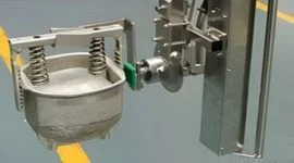 Dalmec stainless steel manipulator gripping tool holding a ham mould in a food processing facility