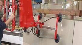 Dalmec manipulator with wheeled vacuum suction frame handling a large glass sheet in a glazing and construction facility