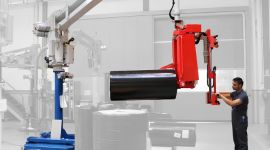 Dalmec pneumatic manipulator lifting and positioning a large paper reel in a paper and printing production facility.
