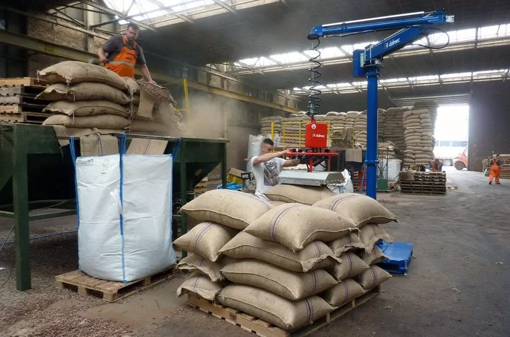 Dalmec pneumatic manipulator with vacuum lifter handling heavy hessian sacks in a warehouse
