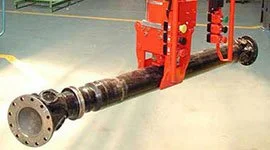 Dalmec industrial manipulator gripping and handling a long transmission shaft in a mechanical workshop