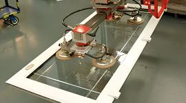 Dalmec vacuum manipulator handling architectural glass panels with precision suction cup lifting technology.
