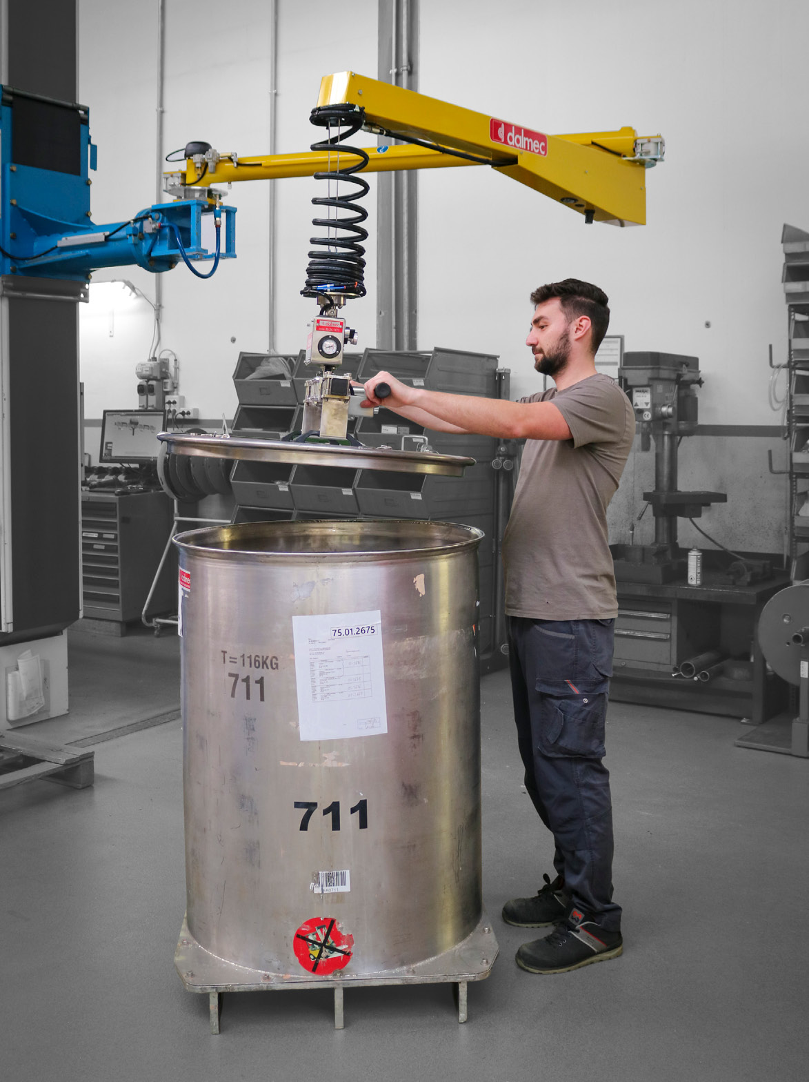 Dalmec manipulator lifting and positioning a stainless steel drum lid for safe operation.