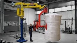 Dalmec manipulator handling plastic extrusion reels for ergonomic lifting and accurate machine loading.