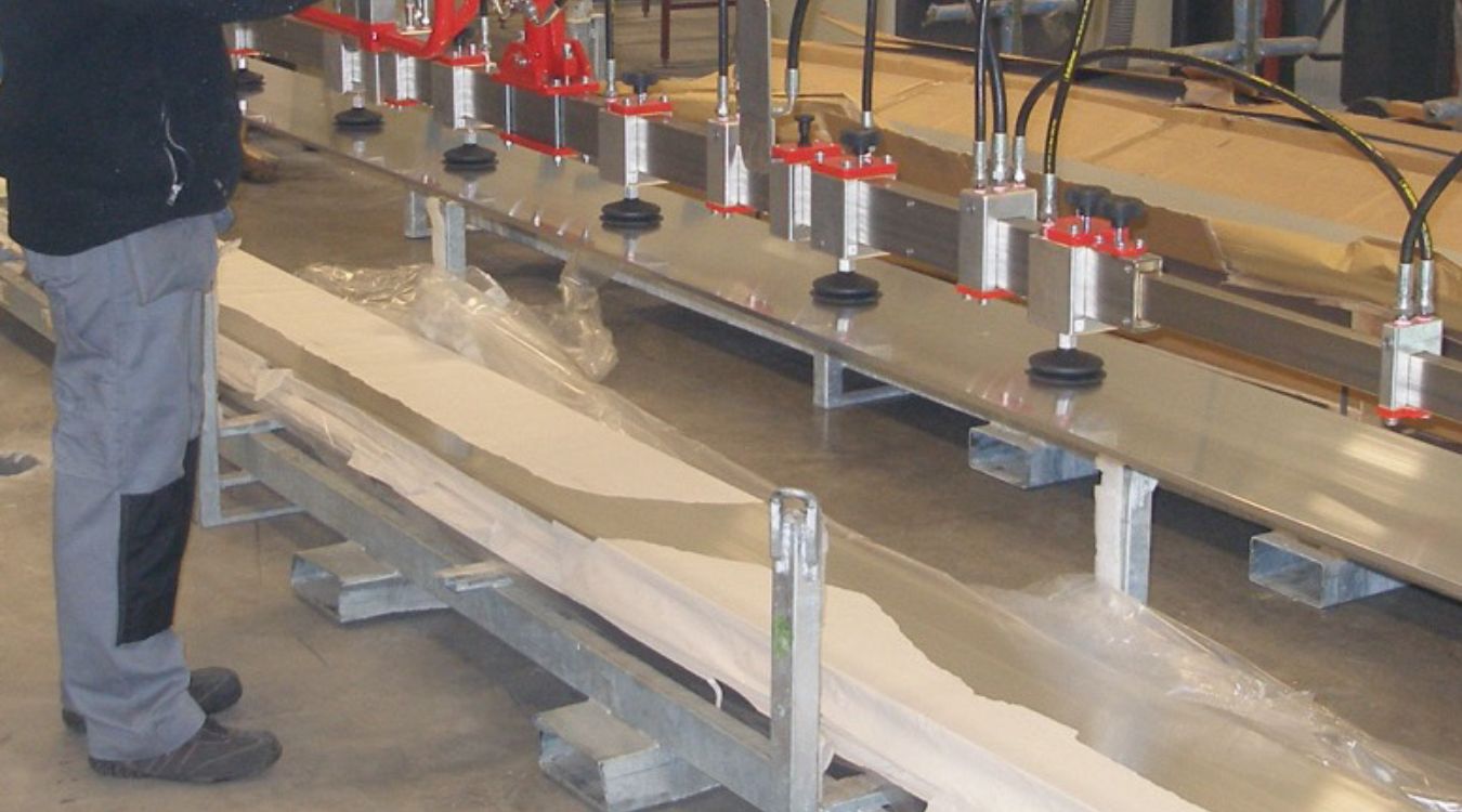 Dalmec pneumatic manipulator handling large furniture components for safe lifting and precision assembly.