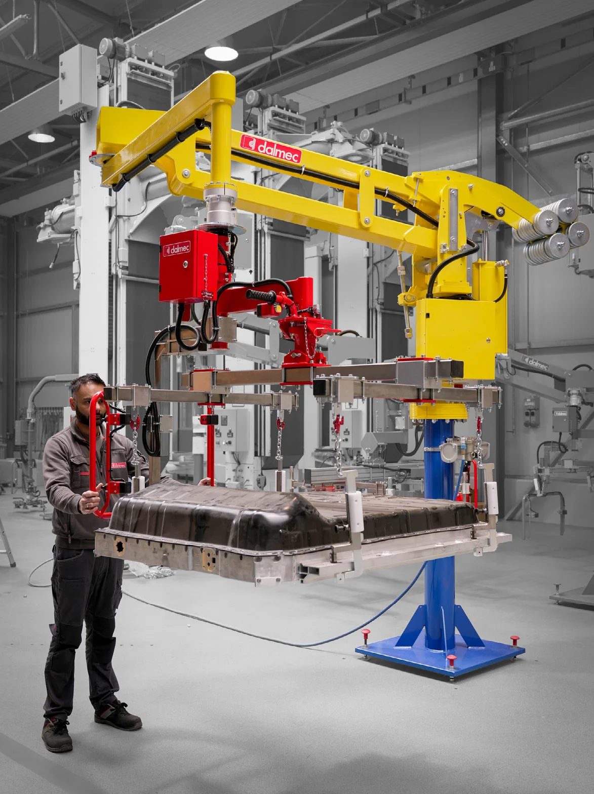 Dalmec pneumatic manipulator positioning a heavy industrial component with balanced load control.