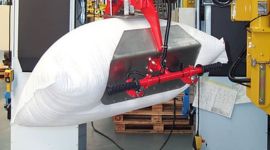 Dalmec manipulator handling plastic resin bags for safe material transfer in a plastics manufacturing facility.