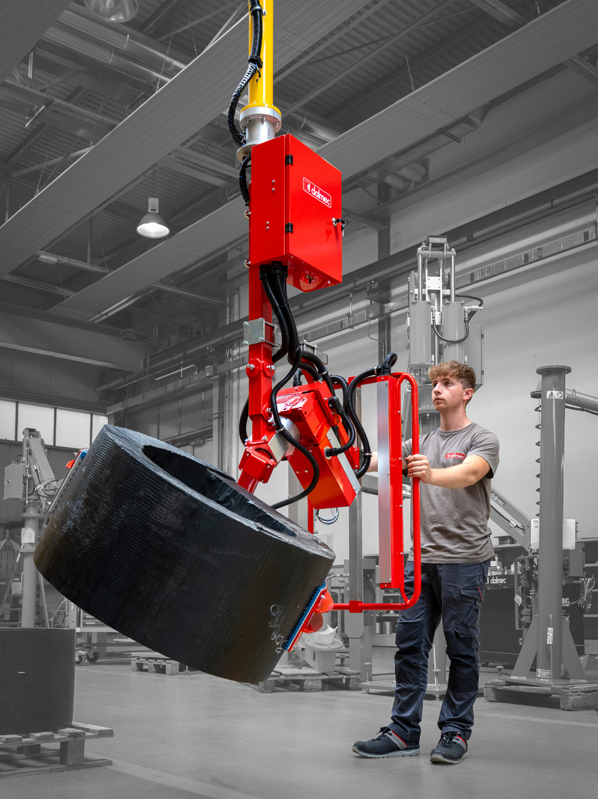 Dalmec manipulator handling a large roll of industrial material with precise positioning.