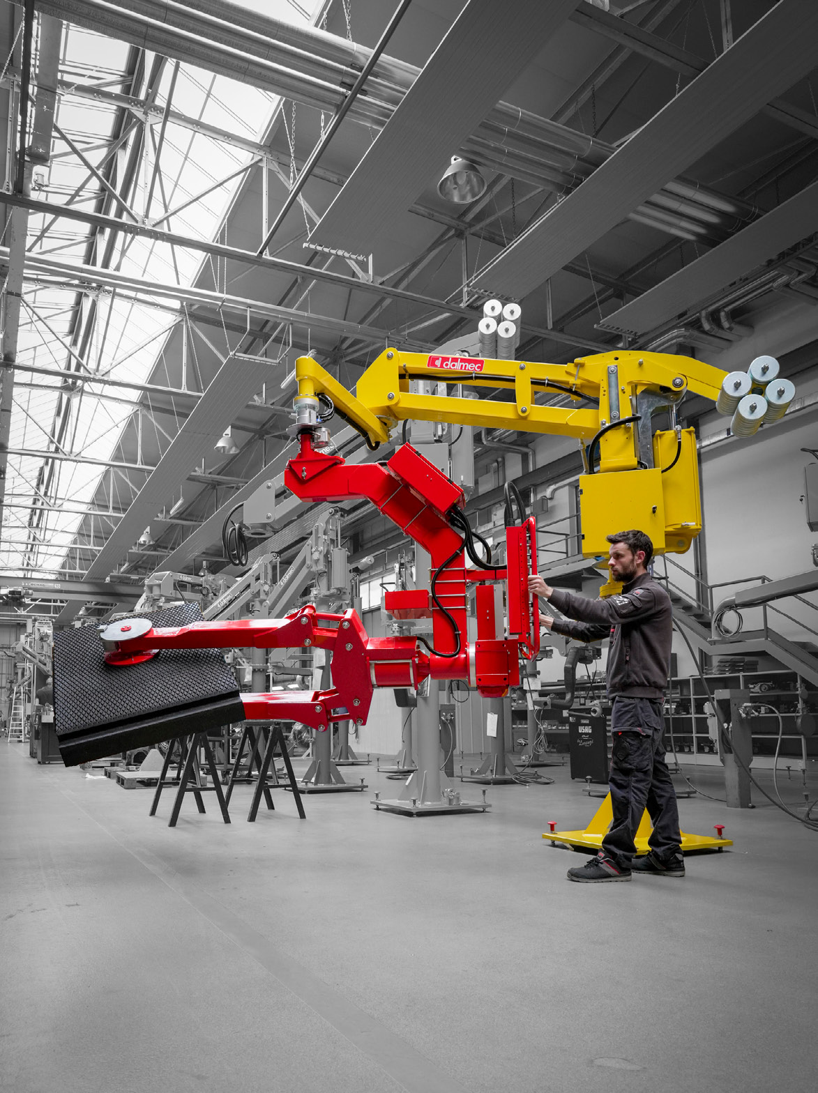 Dalmec manipulator transporting a large rubber roll safely in an industrial production facility.