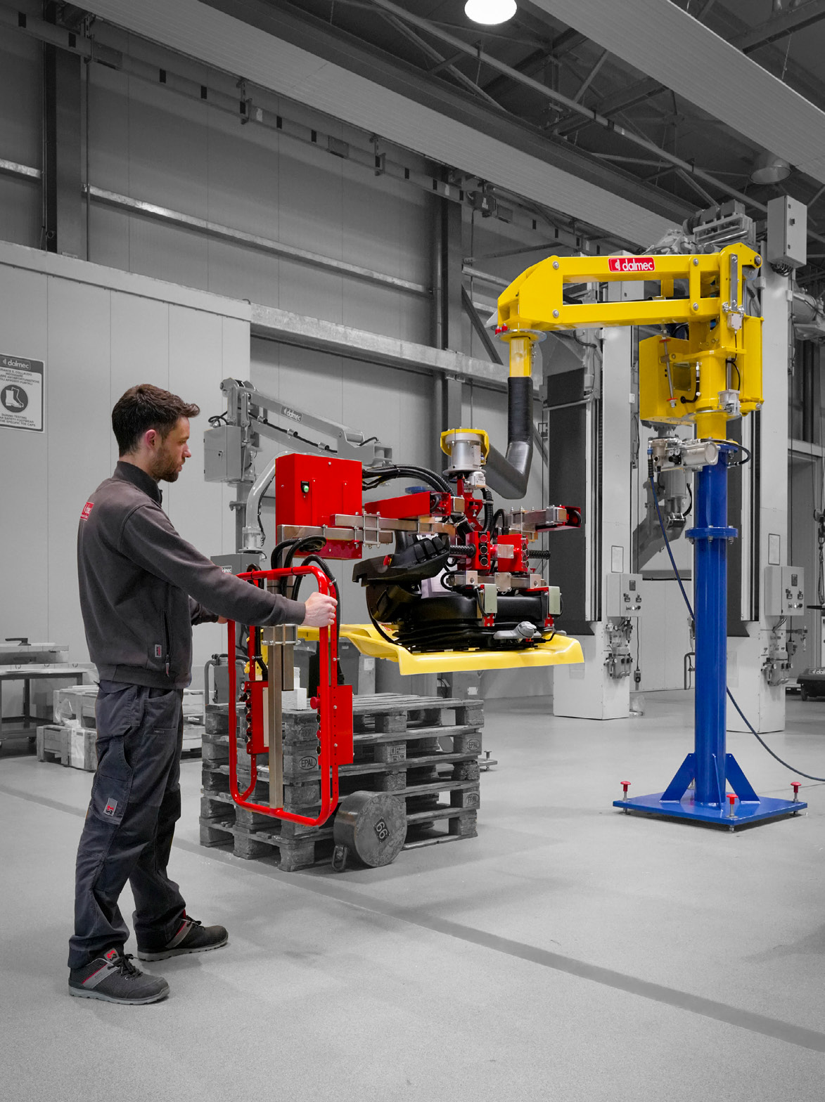 Dalmec ergonomic manipulator lifting an automotive seat component with precision handling.