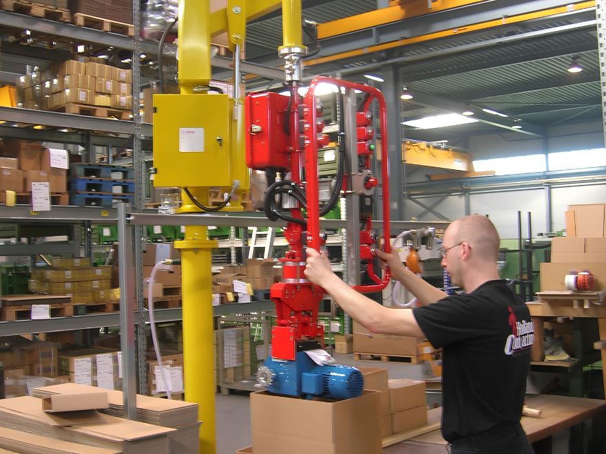 Dalmec pneumatic manipulator lifting a heavy industrial component to improve safety, productivity and ergonomic material handling in an Australian warehouse